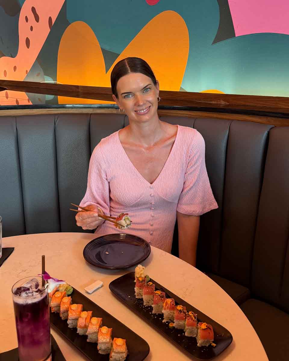 Amy eating sushi at a restaurant table