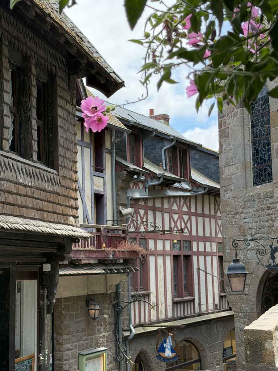 A narrow alleyway with timberframe houses and old iron lampposts